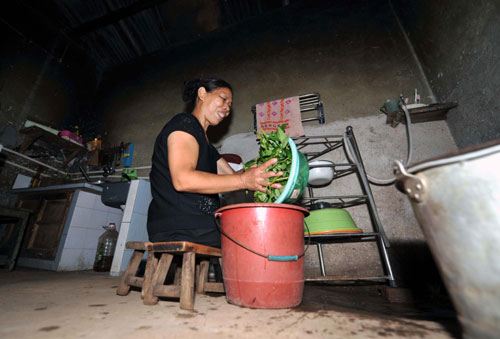 Xu washes vegetables at her home in Xiangtan, Central China&apos;s Hunan province, Sept 15, 2010. [Xinhua]