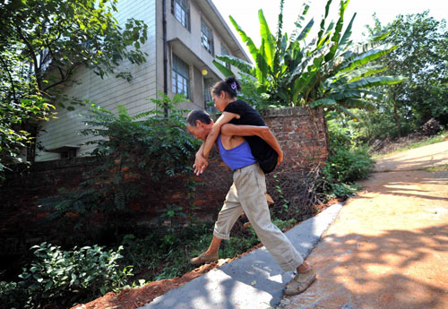 Xu&apos;s husband carries Xu on his back to Xiangtan Social Welfare House from home in Xiangtan, Central China&apos;s Hunan province, Sept 15, 2010. [Xinhua] 
