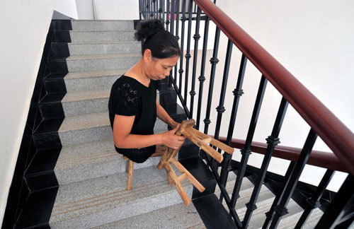 Xu uses two small stools down the stairs at Xiangtan Social Welfare House in Xiangtan, Central China&apos;s Hunan province, Sept 15, 2010. [Xinhua] 
