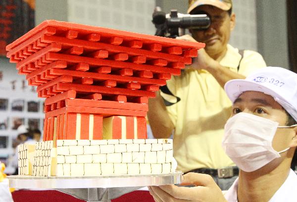 A contestant shows his cake with a similar appearance of Chinese Pavilion in World Expo Shanghai, at a cake decorating competition during the 5th China Suzhou Food Festival in Suzhou, east China's Jiangsu Province, Sept. 20, 2010. The five-day food festival kicked off on Monday, in which many activities would be held, such as cooking competition, cake decorating competition, snacks exhibition and so on. 