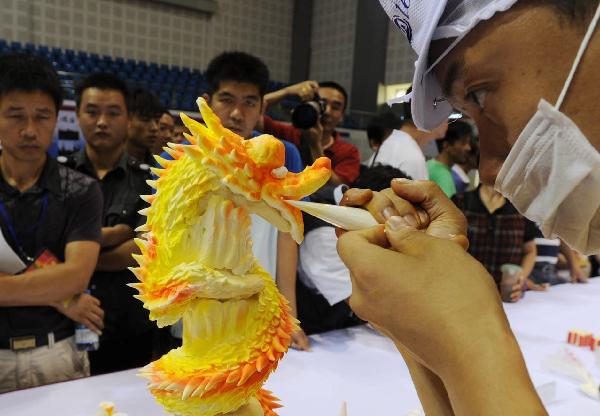 A contestant decorates his cake with cream at a cake decorating competition during the 5th China Suzhou Food Festival in Suzhou, east China's Jiangsu Province, Sept. 20, 2010. The five-day food festival kicked off on Monday, in which many activities would be held, such as cooking competition, cake decorating competition, snacks exhibition and so on.