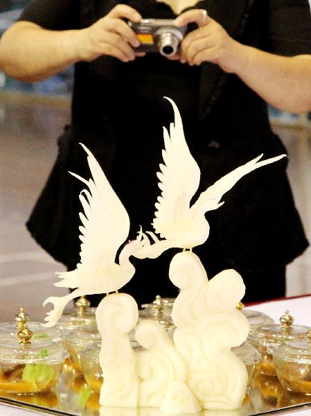 A visitor takes pictures of a dish at a cooking competition during the 5th China Suzhou Food Festival in Suzhou, east China's Jiangsu Province, Sept. 20, 2010. The five-day food festival kicked off on Monday, in which many activities would be held, such as cooking competition, cake decorating competition, snacks exhibition and so on.