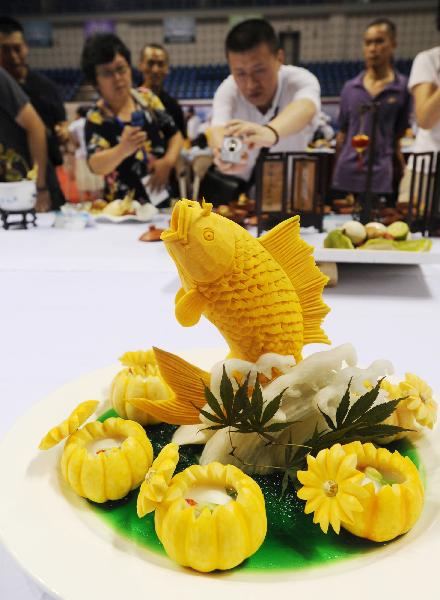 Visitor takes pictures of dishes at a cooking competition during the 5th China Suzhou Food Festival in Suzhou, east China's Jiangsu Province, Sept. 20, 2010. The five-day food festival kicked off on Monday, in which many activities would be held, such as cooking competition, cake decorating competition, snacks exhibition and so on.