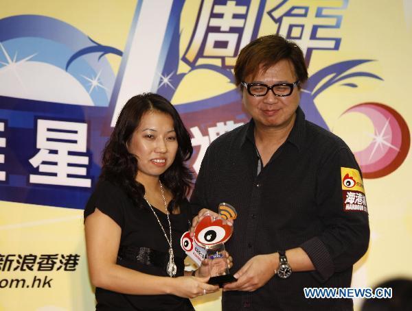 Hong Kong composer Peter Kam (R) takes his trophy for winning the 'Sina Weibo Star-Users Awards' during Sina Weibo Anniversary Celebration in Hong Kong, south China, Sept. 20, 2010.