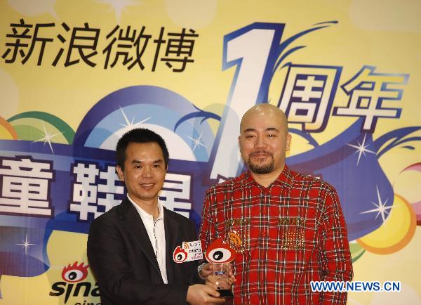Cantopop lyricist Wyman Wong (R) takes his trophy for winning the 'Sina Weibo Star-Users Awards' during Sina Weibo Anniversary Celebration in Hong Kong, south China, Sept. 20, 2010.