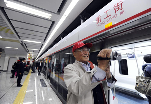 A resident in Shenyang, capital of Northeast China's Liaoning province, takes pictures of the carriages of the city's first subway line in the city, September 22, 2010. More than 100 local residents were invited to experience the line's trial run that day. [Xinhua] 