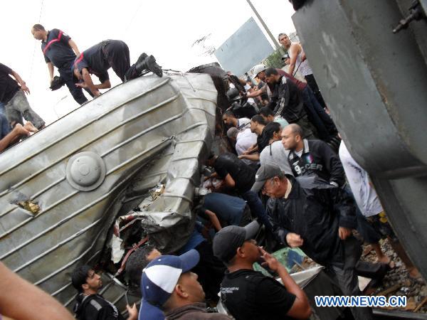 People stand at the spot of a train collision accident in southern Tunis Sept. 24, 2010. One was killed and 57 others injured during a rear-end collision between two trains on Friday. [Xinhua]