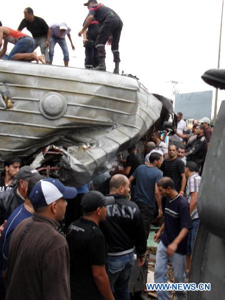 People stand at the spot of a train collision accident in southern Tunis Sept. 24, 2010. [Xinhua]
