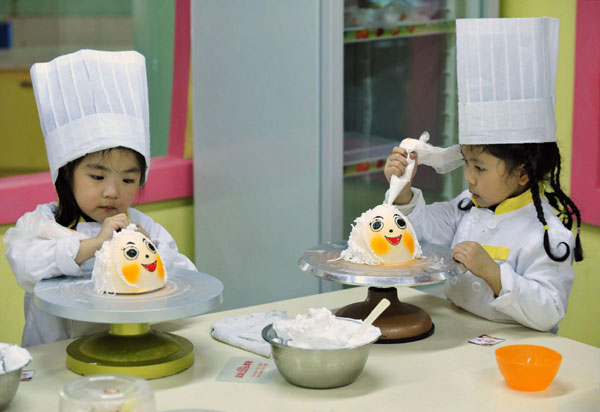 Girls decorate cakes during a cooking class at a youth recreation centre in Shenyang, Liaoning province on Friday. [China Daily/Agencies] 