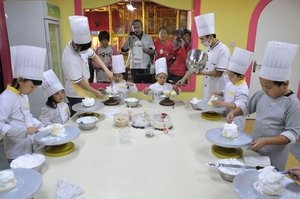 Children make cakes during a cooking class at a youth recreation centre in Shenyang, Liaoning province on Friday.[China Daily/Agencies] 