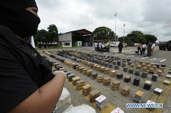 A Panamanian police officer guards cocaine during a presentation to the media at the National Police Station in Panama City, Panama, Sept. 24, 2010. [Xinhua]