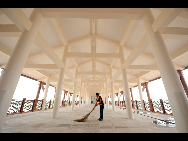 A cleaner rids up a brand-new bridge in the rebuilt Beichuan County, Sept. 14, 2010. [Xinhua]