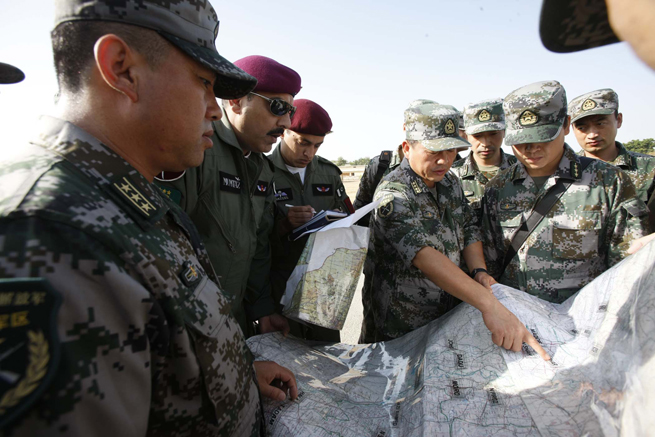 Officials of the Chinese helicopter rescue team discuss the flight course of their first mission with Pakistan air force officials in Hyderabad, Pakistan, Sept. 25, 2010. The Chinese helicopter rescue team accomplished its first mission in flooded areas in Pakistan on Saturday. [Xinhua]