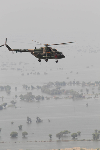 Shen Zhengwen(R), director in chief of the Chinese helicopter rescue team flies the helicopter to a flooded area 160 km away from Hyderabad, Pakistan, Sept. 25, 2010. The Chinese helicopter rescue team accomplished its first mission in flooded areas in Pakistan on Saturday. [Xinhua]