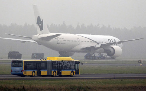 An airport passenger bus drives towards a Pakistan Airlines jet which landed at Arlanda Airport near Stockholm following a bomb threat, Sept 25, 2010. [China Daily/Agencies]