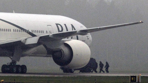 Swedish police approach a Pakistan Airlines jet which landed at Arlanda Airport near Stockholm following a bomb threat Sept 25, 2010. [China Daily/Agencies]