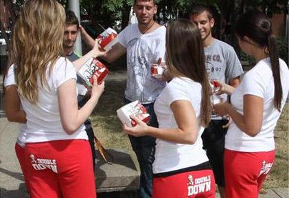 The American fast food chain KFC is currently promoting its new 'Double Down' sandwiches and has recruited attractive female college students to hand out coupons while wearing tracksuit bottoms with the 'Double Down' logo on their backsides.