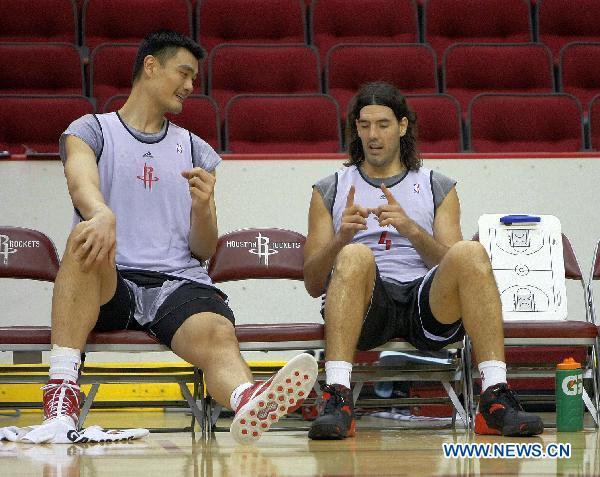 Yao Ming (L) talks with Luis Scola after a training session of Houston Rockets of NBA in Houston, the United States, Sept. 25, 2010. Houston Rockets started its training camp for new season on Saturday. (Xinhua/Song Qiong) 