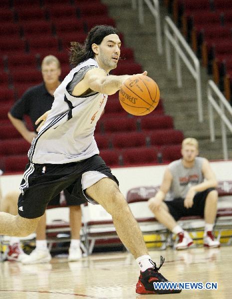 Luis Scola grabs the ball during a training session of Houston Rockets of NBA in Houston, the United States, Sept. 25, 2010. Houston Rockets started its training camp for new season on Saturday. (Xinhua/Song Qiong) 