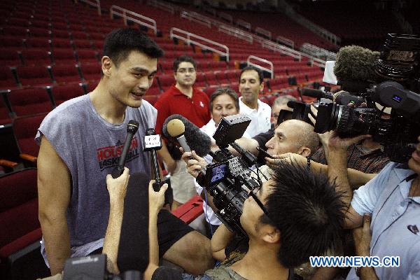 Yao Ming (L) receives interview after a training session of Houston Rockets of NBA in Houston, the United States, Sept. 25, 2010. Houston Rockets started its training camp for new season on Saturday. (Xinhua/Song Qiong) 