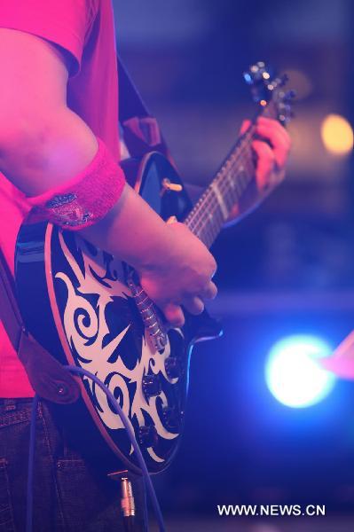 A musician plays guitar during the World Revolution Music Festival in Macao, south China, Sept. 25, 2010. The musical events aimed to promote an anti-drugs society.