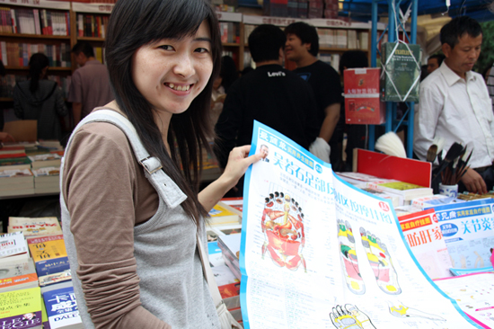 A vendor shows a picture of foot massage methods at the 9th Beijing Book Fair held in the Ditan Park, Beijing, Sept 24, 2010. [chinadaily.com.cn]