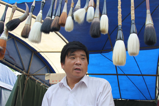 Vendor Zou Jianhua, whose family has a history of making writing brushes for five generations, promotes his writing brushes at the 9th Beijing Book Fair held in the Ditan Park, Beijing, Sept 24, 2010. Zou admits that few Chinese people nowadays know how to write with writing brushes and makers of the traditional writing tool face increasing pressure, but he also believes the quality decides the market. [chinadaily.com.cn]