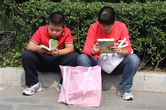 Visitors read books at the 9th Beijing Book Fair held in the Ditan Park, Beijing, Sept 24, 2010. [chinadaily.com.cn]