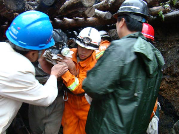 Rescuers carry a miner onto an ambulance after being rescued from a tin mine after a dam at the mine collapsed due to a landslide in Songtao County, Southwest China&apos;s Guizhou Province, Sept 26, 2010. All the eight trapped miners were rescued Sunday afternoon. [Xinhua]