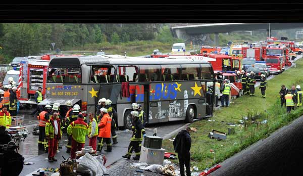 Emergency services stand next to the wreckage of a bus and a car following an accident on the A10 motorway near Schoenfeld south of Berlin September 26, 2010. [Xinhua/AFP]