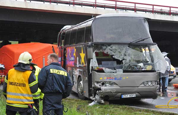 Emergency services stand next to the wreckage of a bus and a car following an accident on the A10 motorway near Schoenfeld south of Berlin September 26, 2010. [Xinhua/AFP]