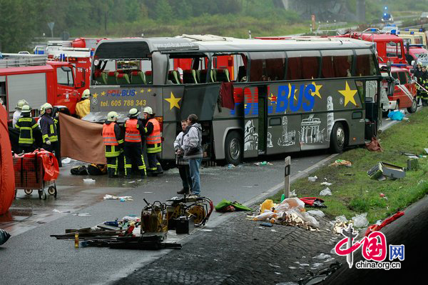 Firemen and rescue workers stand around a tour bus that crashed into a concrete bridge support on the A10 highway on September 26, 2010 near Berlin, Germany. According to police on site at least 11 people were killed and 7 seriously injured. According to medai reports the bus was carrying Polish youth home from a trip to Spain and the bus crashed after attempting to pass a merging car. [CFP]