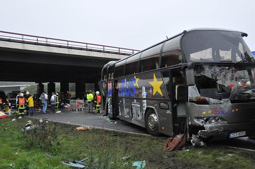 Emergency services stand next to the wreckage of a bus and a car following an accident on the A10 motorway near Schoenfeld south of Berlin September 26, 2010. [Xinhua/AFP]