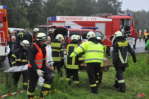 Emergency services stand next to the wreckage of a bus and a car following an accident on the A10 motorway near Schoenfeld south of Berlin September 26, 2010. [Xinhua/AFP]