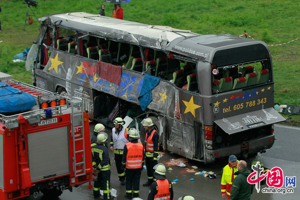 Firemen and rescue workers stand around a tour bus that crashed into a concrete bridge support on the A10 highway on September 26, 2010 near Berlin, Germany. According to police on site at least 11 people were killed and 7 seriously injured. According to medai reports the bus was carrying Polish youth home from a trip to Spain and the bus crashed after attempting to pass a merging car. [CFP]