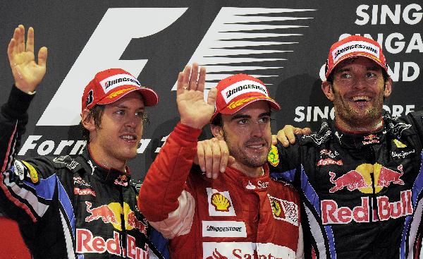 Winner Ferrari Formula One driver Fernando Alonso (C) of Spain, second-placed Red Bull driver Sebastian Vettel of Germany and third-placed Red Bull driver Mark Webber (R) of Australia waves after winning the Singapore F1 Grand Prix at the Marina Bay Street Circuit September 26, 2010. (Xinhua/AFP Photo)