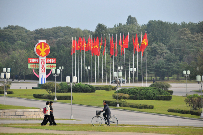 Photo taken on Sept. 27, 2010 shows people walking and riding at a square decorated with flags and posters in Pyongyang, capital of the Democratic People&apos;s Republic of Korea (DPRK). [Xinhua]