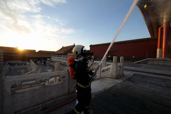 A firefighter participates in a fire drill in front of the Hall of Supreme Harmony (Taihe Dian) of the Forbidden City in Beijing, Sept 27, 2010. Beijing&apos;s fire control departments have increased the frequency of fire drills ahead of the seven-day National Day holiday, which whill see a peak in tourists in the capital. [Xinhua]