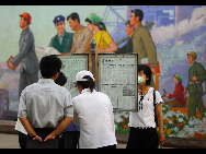 Local people read newspapers inside a subway station in Pyongyang, capital of the Democratic People's Republic of Korea (DPRK), Aug. 11, 2010. [Xinhua]