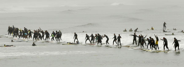 South African surfers take to the water in an attempt to break the Guinness World Record for the highest number of riders on a single wave at Muizenberg in Cape Town, Sept 26, 2010. The surfers posted an unofficial tally of 95 riders standing on a single wave for more than five seconds but failed to beat the record of 110. [China Daily/Agencies] 