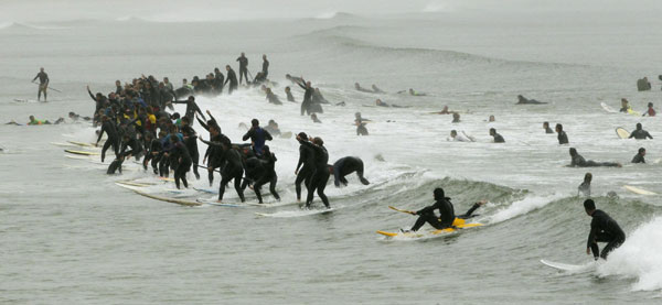 South African surfers take to the water in an attempt to break the Guinness World Record for the highest number of riders on a single wave at Muizenberg in Cape Town, Sept 26, 2010. [China Daily/Agencies]