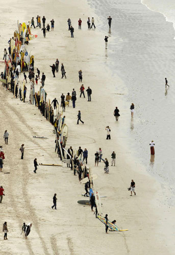 Surfers prepare to take to the water in an attempt to break the Guinness World Record for the highest number of riders on a single wave at Muizenberg in Cape Town, Sept 26, 2010. [China Daily/Agencies]