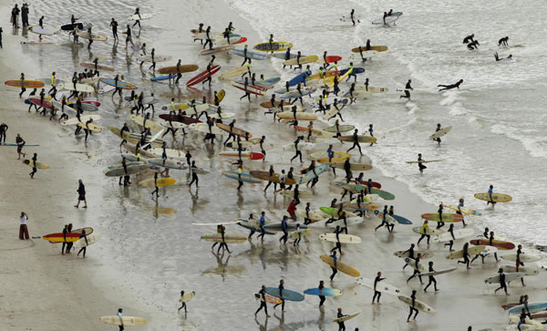 South African surfers take to the water in an attempt to break the Guinness World Record for the highest number of riders on a single wave at Muizenberg in Cape Town, Sept 26, 2010. [China Daily/Agencies]