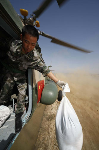 A Chinese People&apos;s Liberation Army officer drops relief materials in flood-hit Pakistan, Sept 27, 2010. [Xinhua]