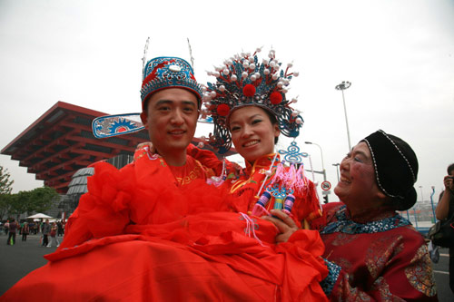 A couple poses for photos during their wedding ceremony in front of the China Pavilion at the Shanghai World Expo, Sept 27, 2010. [Xinhua]