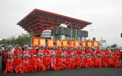 Twenty newly married couples pose for a group photo at a traditional folk wedding ceremony in front of the China Pavilion at the Shanghai World Expo, Sept 27, 2010. [Xinhua] 