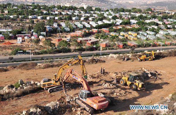 Construction vehicles work as the building of a housing project resumes in the West Bank Jewish settlement of Ariel, Sept. 27, 2010. The moratorium on Israeli construction in West Bank settlements, declared by Prime Minister Benjamin Netanyahu last November, expired at midnight on Sunday. [Yin Dongxun/Xinhua]