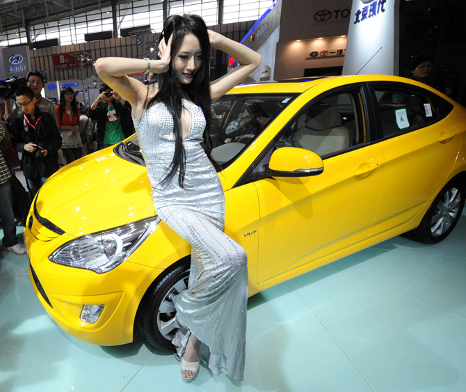 A model displays a vehicle during the 2010 Nanjing International Auto Show in Nanjing, capital of east China&apos;s Jiangsu Province, Sept. 28, 2010. The seven-day auto show, displaying more than 500 vehicles of 75 brands, kicked off at Nanjing International Expo Center on Tuesday. [Xinhua]