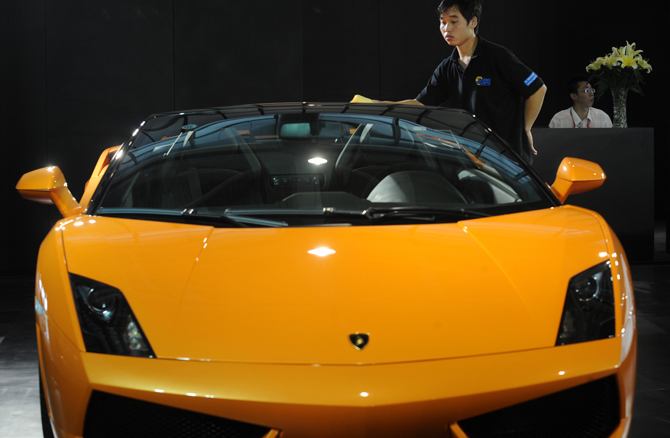 A worker cleans the surface of an import vehicle during the 2010 Nanjing International Auto Show in Nanjing, capital of east China&apos;s Jiangsu Province, Sept. 28, 2010. The seven-day auto show, displaying more than 500 vehicles of 75 brands, kicked off at Nanjing International Expo Center on Tuesday. [Xinhua]