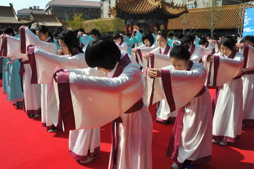  Students dressed with traditional Chinese clothes during Han Dynasty bow to teachers at a coming-of-age ceremony on the 2561st anniversary of Confucius&apos; birth at the Confucius Temple in Jinan, East China&apos;s Shandong province, Sept 28, 2010. [Xinhua]